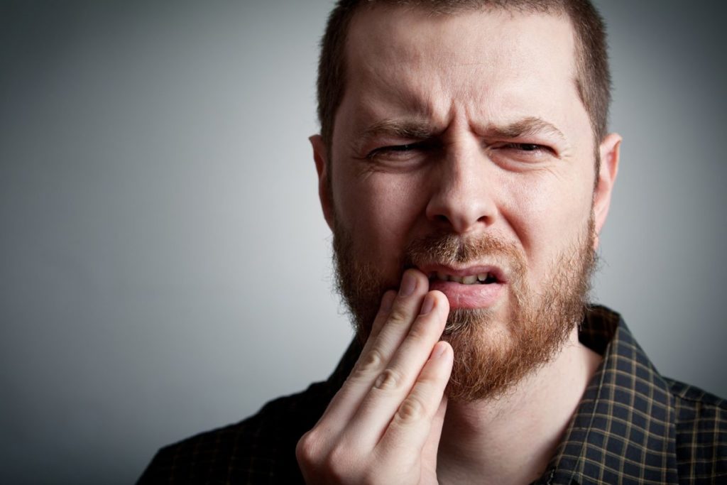 northwest-houston-patient-with-dental-emergency man with dental emergency in Houston holding facing